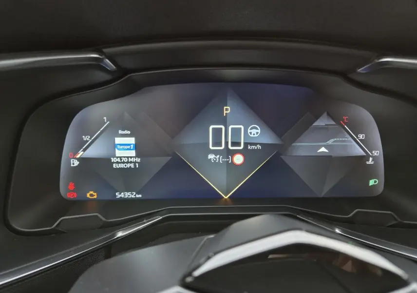 Tableau de bord numérique du DS7 Crossback 2022 affichant la vitesse, la radio et les indicateurs, vue frontale rapprochée.