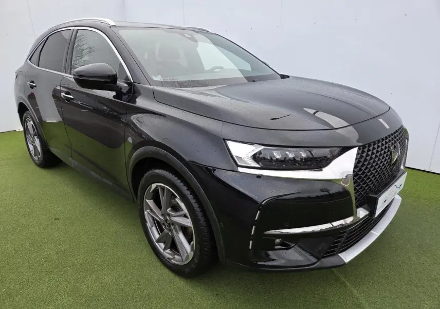 DS7 Crossback noir Perla Metal vu en 3/4 avant droit, avec calandre noire brillante et jantes alliage distinctives.