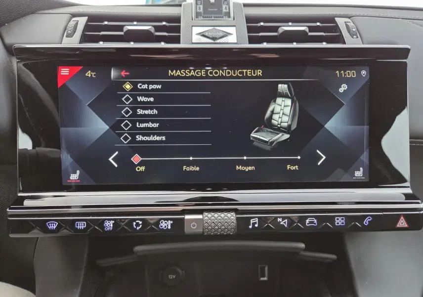 Écran tactile central du DS7 Crossback noir montrant les réglages du massage siège conducteur avec horloge analogique au-dessus.