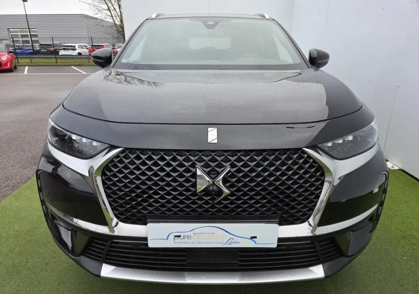 Vue de face d'un DS7 Crossback noir Perla Metal avec calandre noire à motif losange et logo DS central chromé.
