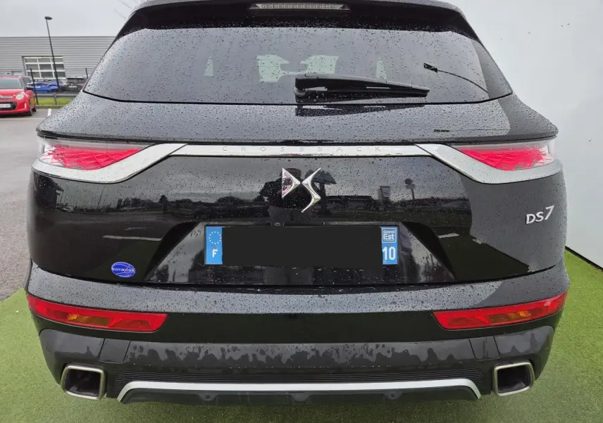 Vue arrière d'un DS7 Crossback noir perla metal avec feux arrière 3D et double sortie d'échappement carrée.