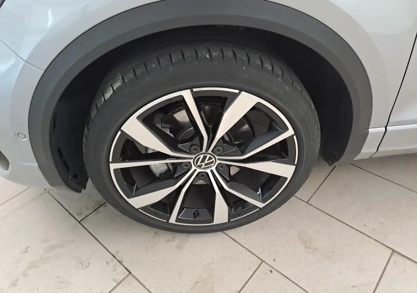 Gros plan sur la jante alliage 19'' Misano noire et argent du Volkswagen T-Roc gris pyrite, côté avant droit.