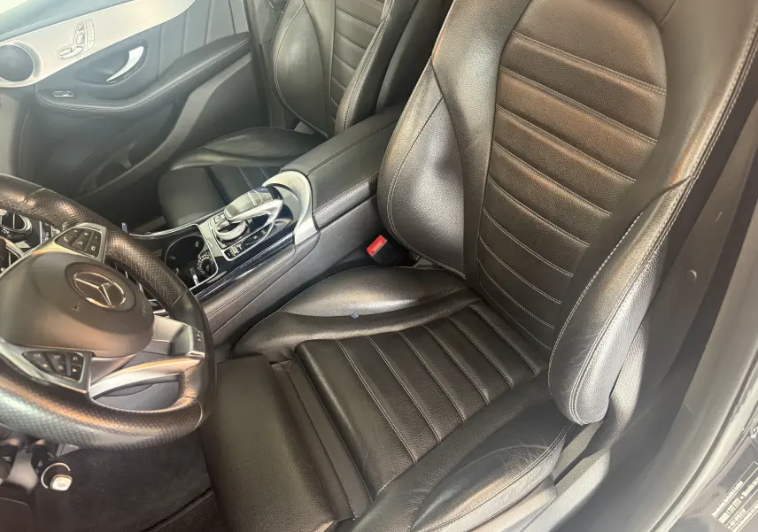 Vue intérieure côté conducteur du Mercedes GLC Coupé noir 2018, mettant en valeur le siège en cuir et la console centrale AMG.