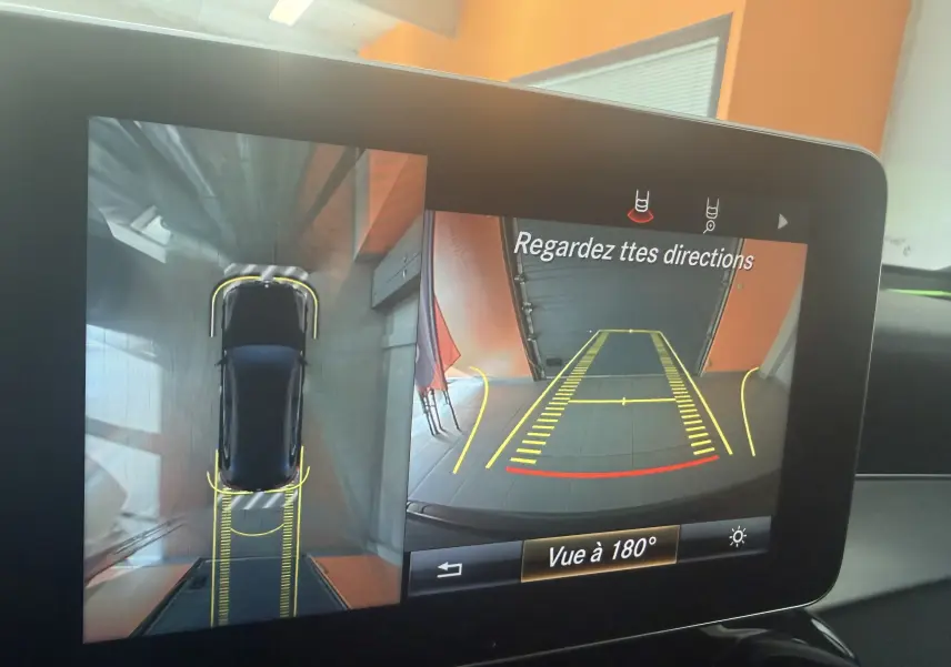 Écran de caméra 360° montrant une Mercedes GLC Coupé noire vue de dessus et en recul dans un garage.