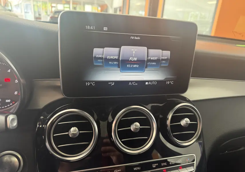 Vue rapprochée du tableau de bord du Mercedes GLC Coupé noir 2018, avec écran central et aérateurs ronds chromés.