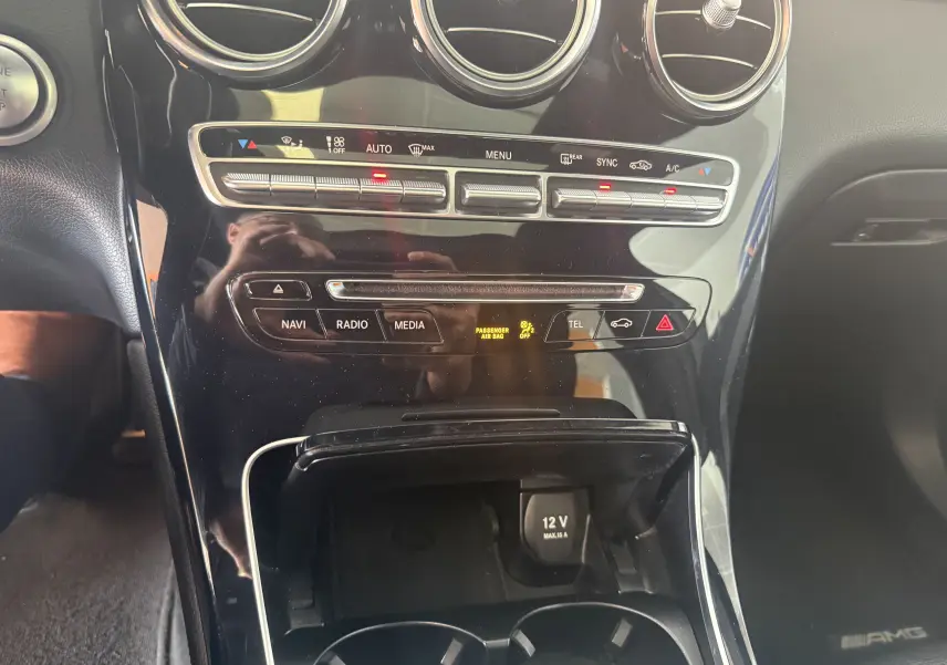 Vue rapprochée de la console centrale noire du Mercedes GLC Coupé 2.2 170d Sportline AMG avec commandes clim et multimédia.