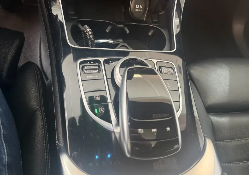 Vue rapprochée de la console centrale noire du Mercedes GLC Coupé 2.2 170d Sportline AMG avec commandes tactiles et molette.