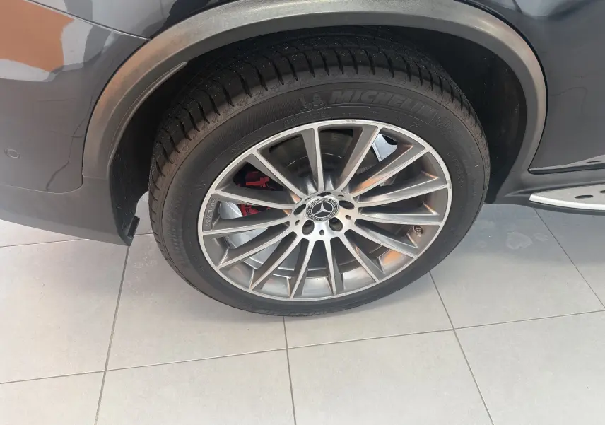 Gros plan sur la roue avant gauche du Mercedes GLC Coupé noir, avec jante AMG et étrier de frein rouge visible.