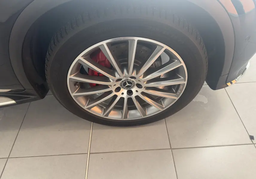 Gros plan sur la roue avant droite du Mercedes GLC Coupé noir 2018, jante AMG argentée avec étrier de frein rouge visible.