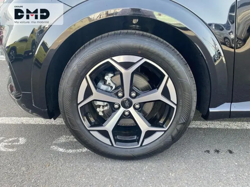 Gros plan sur la roue avant gauche d'une Ford Puma noire Agate Métallisée avec jante alu au design moderne.