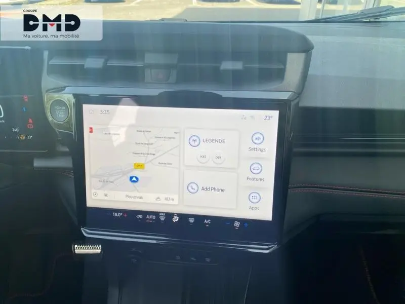 Vue intérieure centrée sur l'écran tactile du tableau de bord du Ford Puma noir avec finitions rouges et commandes digitales.