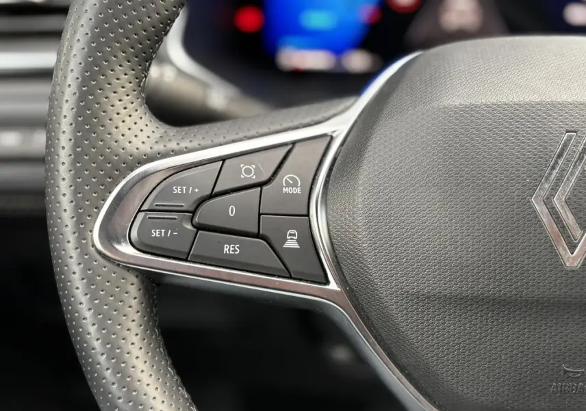 Gros plan sur les commandes à gauche du volant perforé noir du Renault Symbioz E-Tech Full Hybrid 2025.