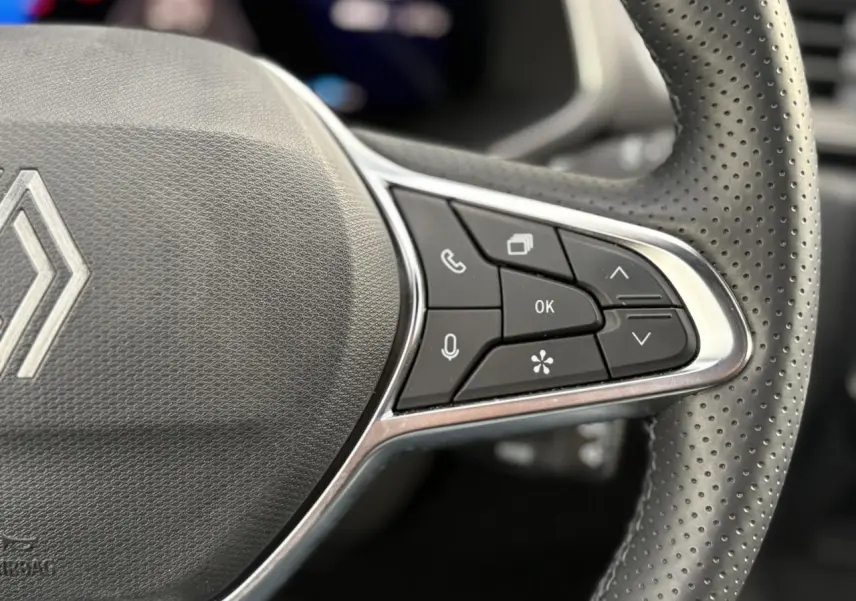 Gros plan sur le côté droit du volant perforé de la Renault Symbioz 2025 avec commandes multifonctions intégrées.