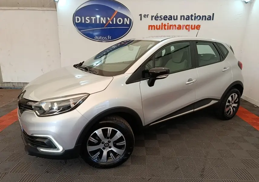 Renault Captur Zen TCe 90 gris clair en 3/4 avant droit, avec jantes alliage et rétroviseurs noirs brillants.