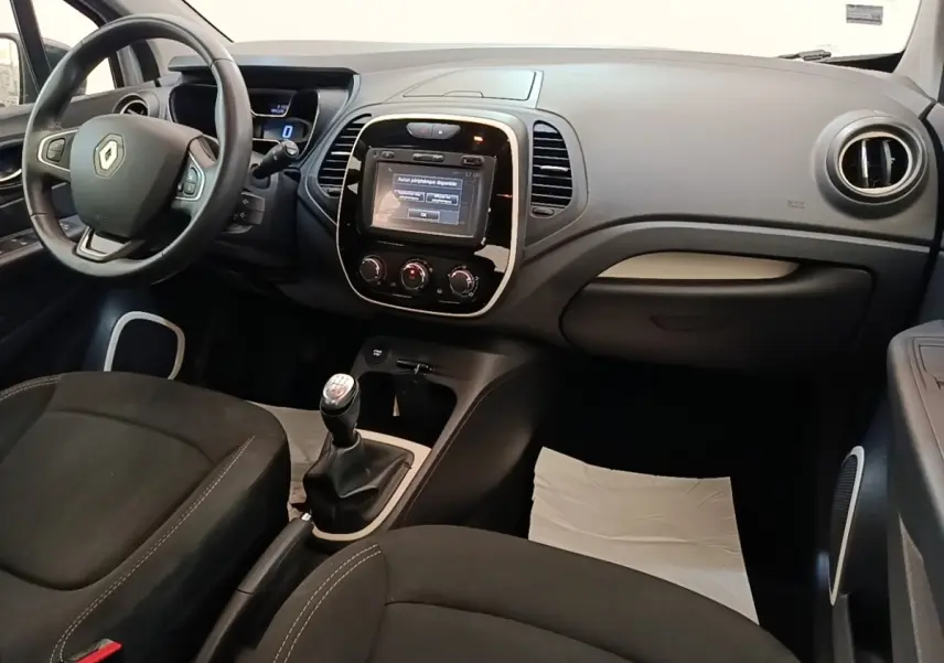 Vue intérieure avant droite du Renault Captur Zen TCe 90 2018, tableau de bord gris avec écran tactile et boîte manuelle.