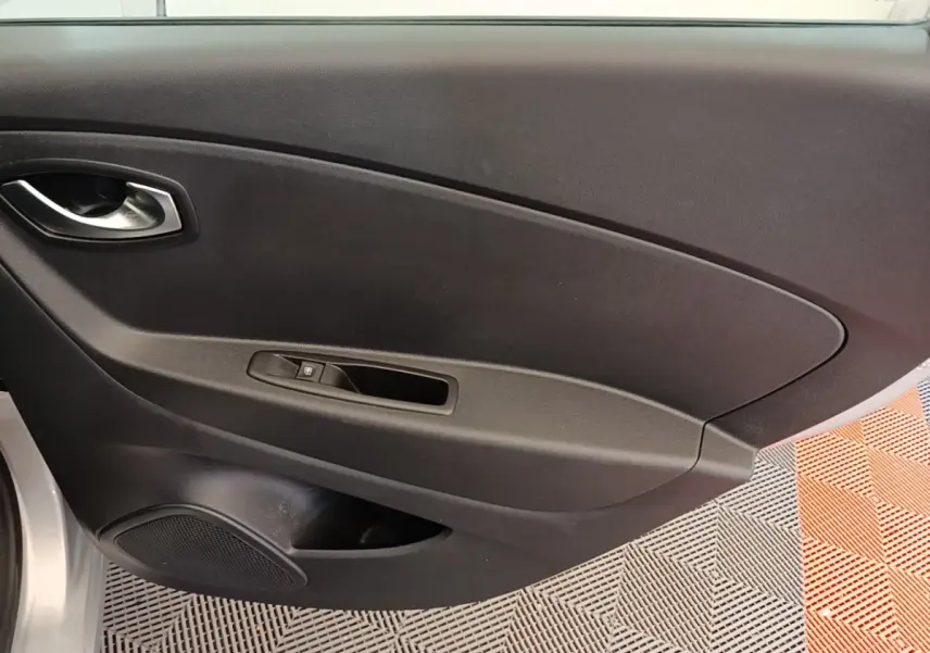 Gros plan sur la porte intérieure côté droit du Renault Captur gris clair, avec poignée et commande de vitre électrique.