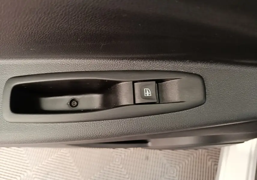 Gros plan sur le bouton de commande de la vitre électrique côté conducteur d’un Renault Captur gris clair 2018.