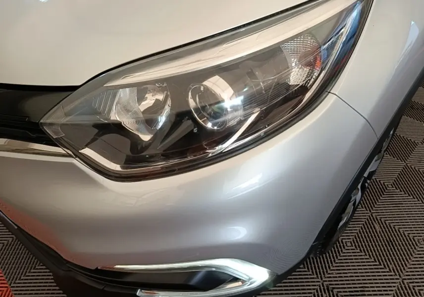Gros plan sur le phare avant droit gris clair du Renault Captur Zen TCe 90 de 2018 avec feu de jour LED allumé.