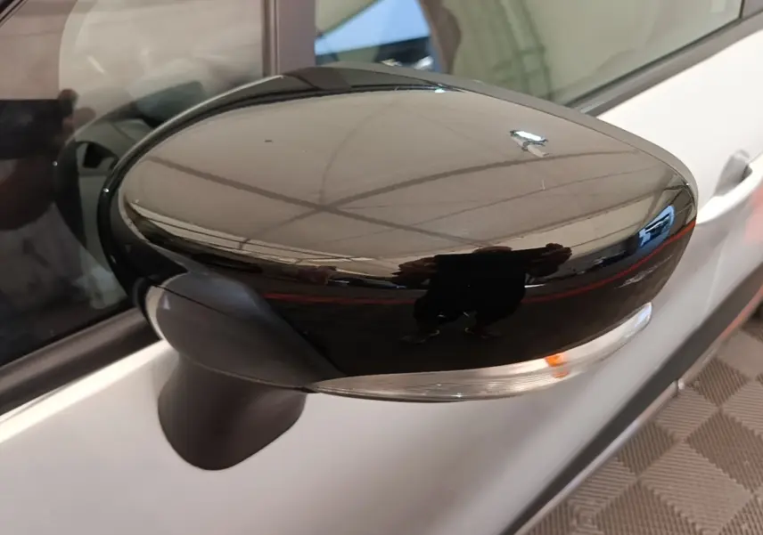 Rétroviseur droit noir brillant du Renault Captur gris clair, vue rapprochée sur la portière côté droit.