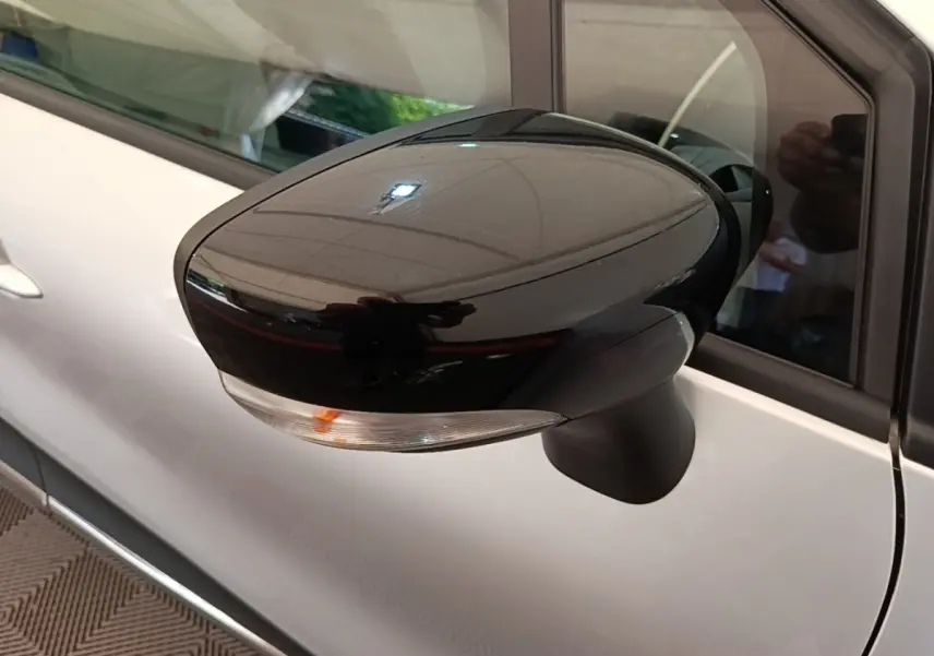 Rétroviseur noir brillant côté gauche du Renault Captur gris clair 2018, avec clignotant intégré visible.