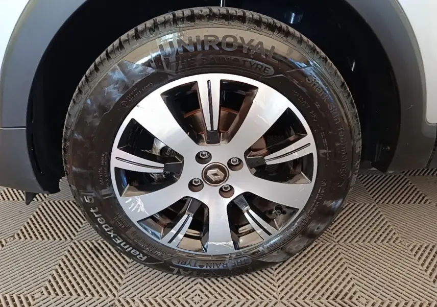 Gros plan sur la roue avant droite d’un Renault Captur gris clair, mettant en valeur la jante alliage et le pneu Uniroyal.