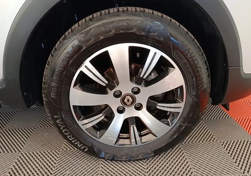 Gros plan sur la roue avant droite du Renault Captur gris clair, mettant en valeur la jante alliage et le pneu Uniroyal.