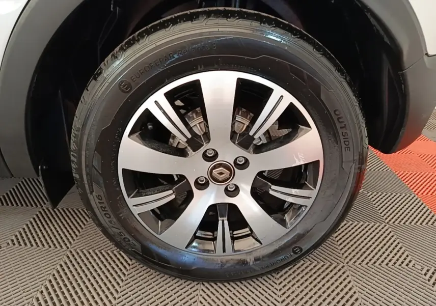 Gros plan sur la roue avant droite du Renault Captur gris clair, mettant en valeur la jante alliage et le pneu.