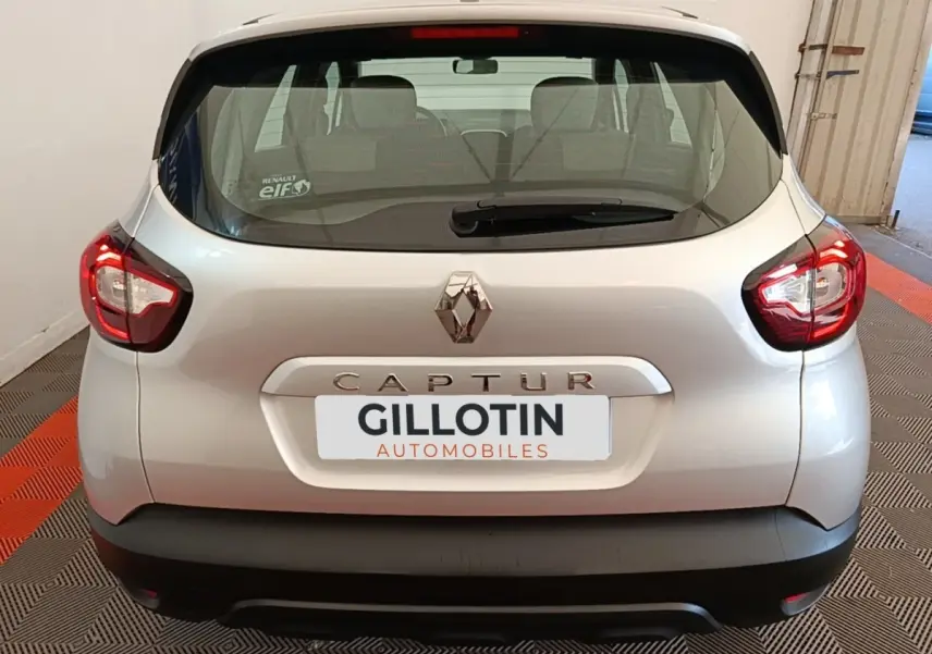 Vue arrière d'un Renault Captur gris clair de 2018 avec feux arrière LED et logo Renault bien visible.