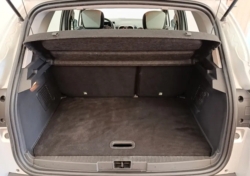 Coffre ouvert d’un Renault Captur gris clair 2018, vue arrière montrant l’espace de chargement et la tablette amovible.