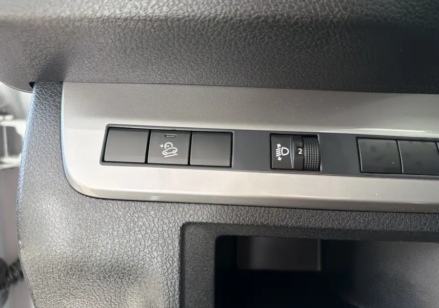 Détail intérieur du tableau de bord du Fiat Scudo Fourgon blanc 2025, avec commandes de régulateur et réglage des phares.