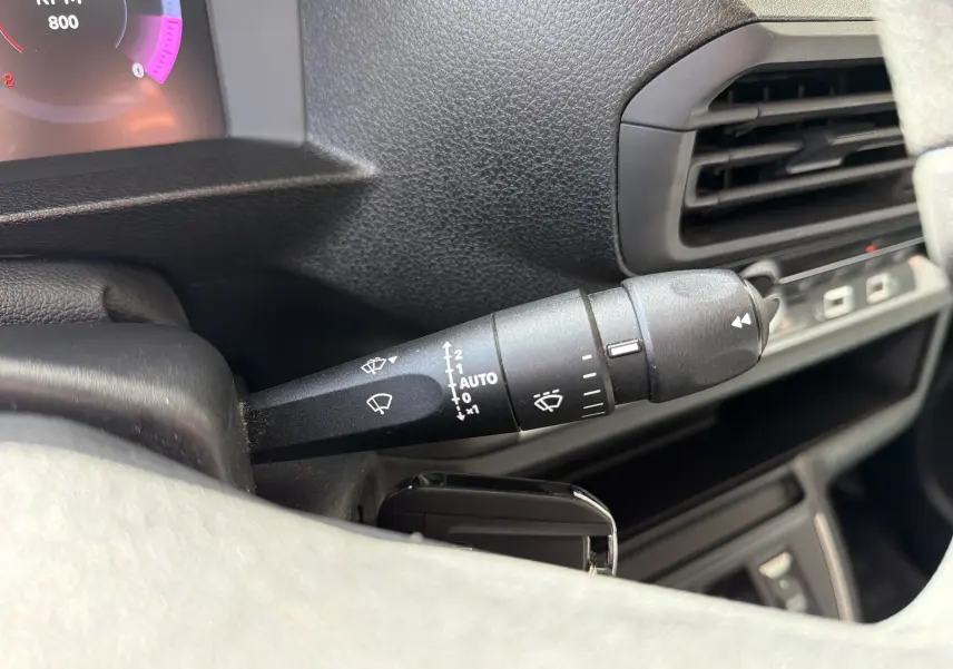 Gros plan sur la commande des essuie-glaces côté gauche du tableau de bord noir du Fiat Scudo Fourgon blanc 2025.
