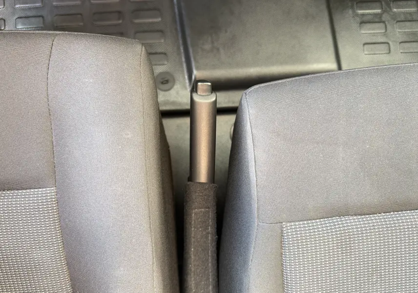 Vue rapprochée de la poignée de frein à main entre deux sièges gris du Fiat Scudo Fourgon XL 180 2025.