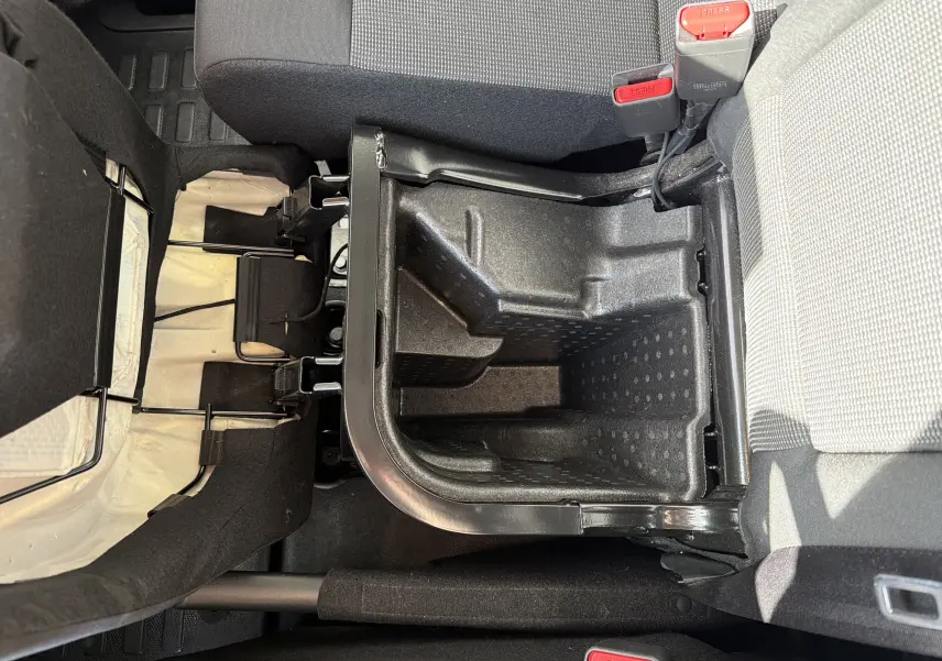 Vue intérieure rapprochée du coffre de rangement sous la banquette arrière grise du Fiat Scudo Fourgon XL 2025.