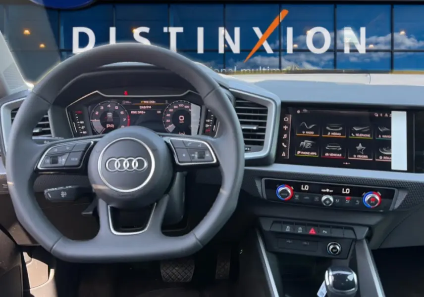 Vue intérieure du poste de conduite de l'Audi A1 Sportback 30 TFSI 116 S line 2026 avec volant cuir et écran tactile.