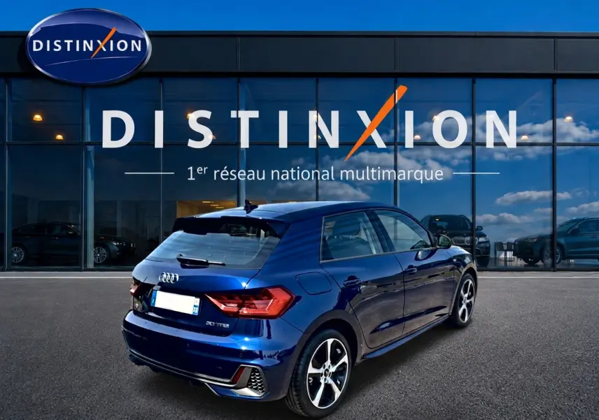 Audi A1 Sportback bleu foncé vue 3/4 arrière droit, avec jantes alliage et becquet arrière noir.