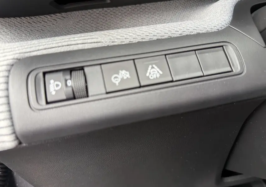 Vue rapprochée des boutons de commande sur la porte côté conducteur d'une Citroën C3 hybride gris Mercury avec toit noir.