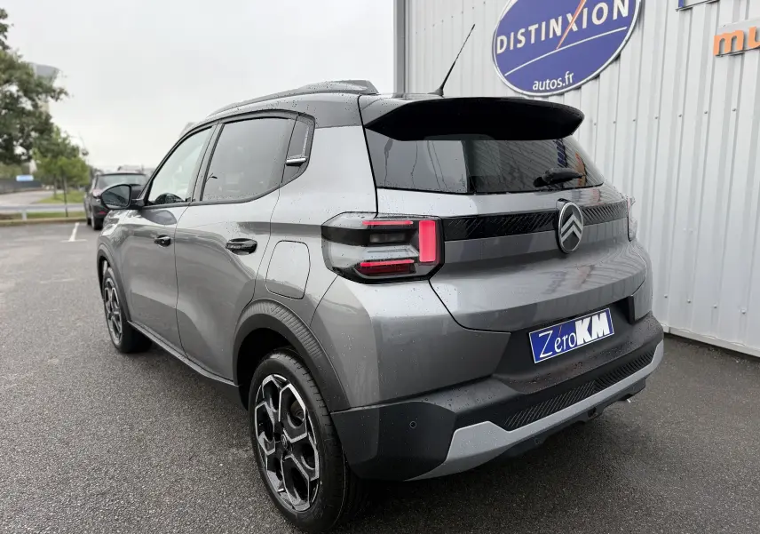Vue 3/4 arrière droite d'une Citroën C3 hybride gris Mercury avec toit noir et feux arrière LED distinctifs.
