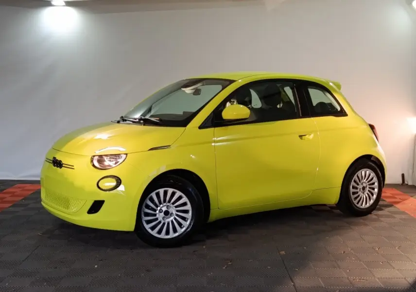 Vue de profil droit d'une FIAT 500 électrique jaune vif avec jantes argentées dans un studio.