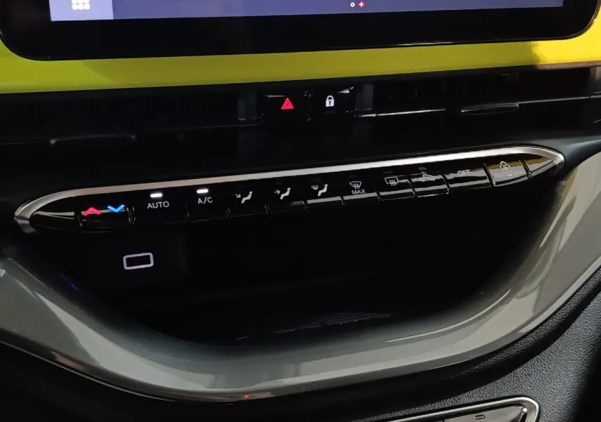 Vue rapprochée de la console centrale du Fiat 500 BEV 24KWH 2024, boutons de climatisation et écran tactile visible.