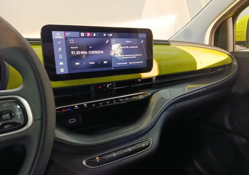 Vue intérieure côté passager du tableau de bord jaune vif du Fiat 500 BEV 2024 avec écran tactile central large.