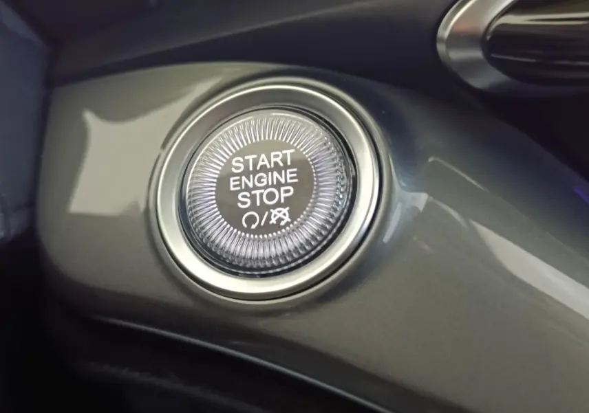 Bouton démarrage Start Engine Stop en gros plan sur tableau de bord gris du Fiat 500 électrique 2024.