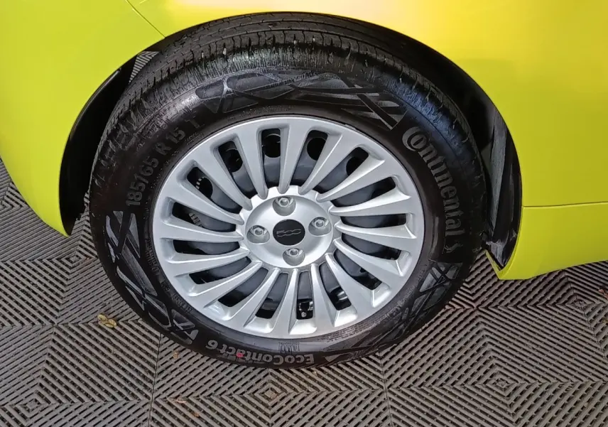 Gros plan sur la roue avant droite d'une FIAT 500 BEV 24KWH jaune, avec jante argentée et pneu Continental.