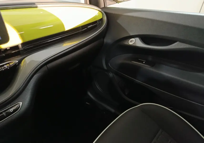 Vue intérieure côté passager du tableau de bord noir et jaune vif du Fiat 500 BEV 24 kWh 2024.