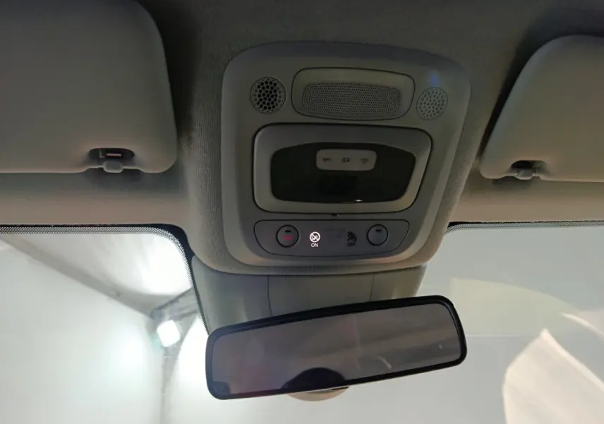 Plafonnier et rétroviseur intérieur d'une Fiat 500 BEV jaune, vue centrée vers l'avant avec commandes éclairage et alertes.