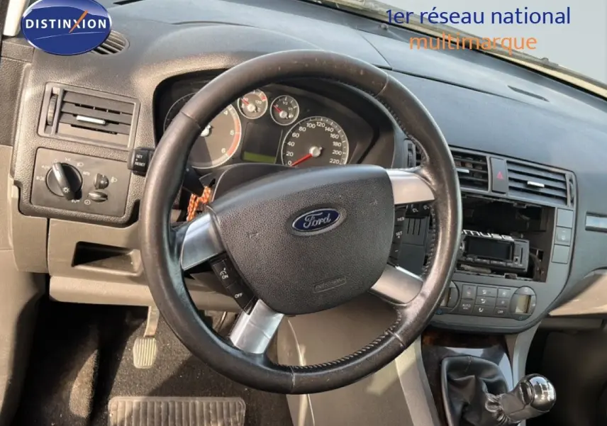 Vue rapprochée de l’intérieur d’une Ford C-MAX 2005, volant cuir et levier de vitesse manuel visibles.
