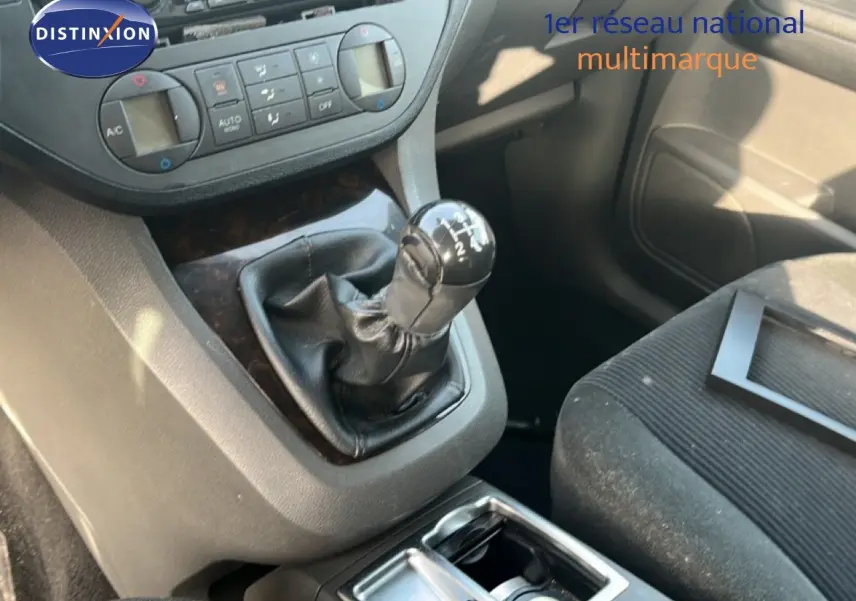 Gros plan sur la boîte manuelle et la console centrale d’un Ford C-MAX 1.6 TDCI bleu foncé, intérieur tissu noir.