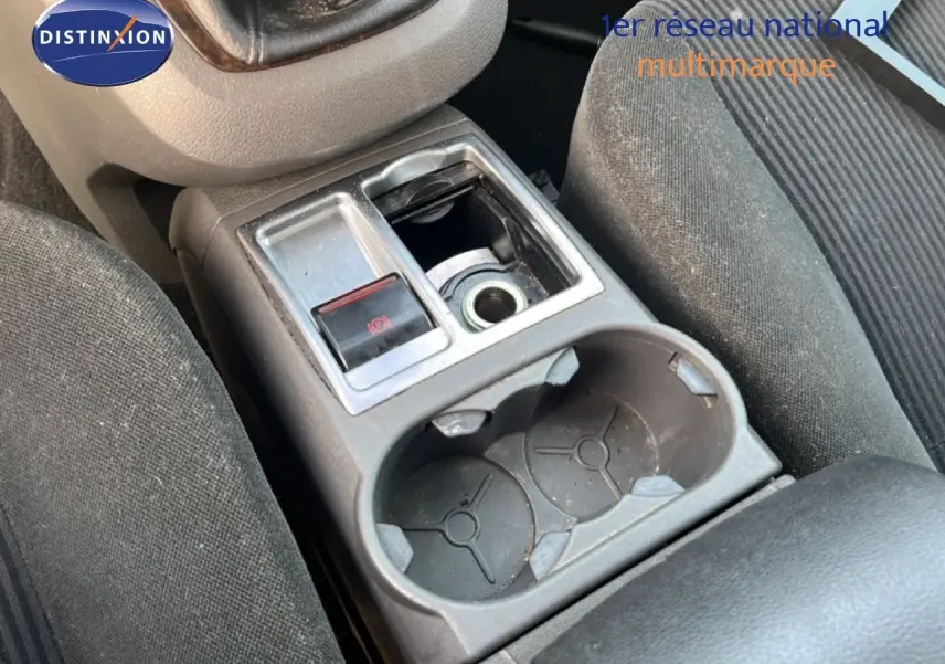 Gros plan sur la console centrale intérieure d'une Ford C-MAX 2005, montrant porte-gobelets et frein à main électrique.