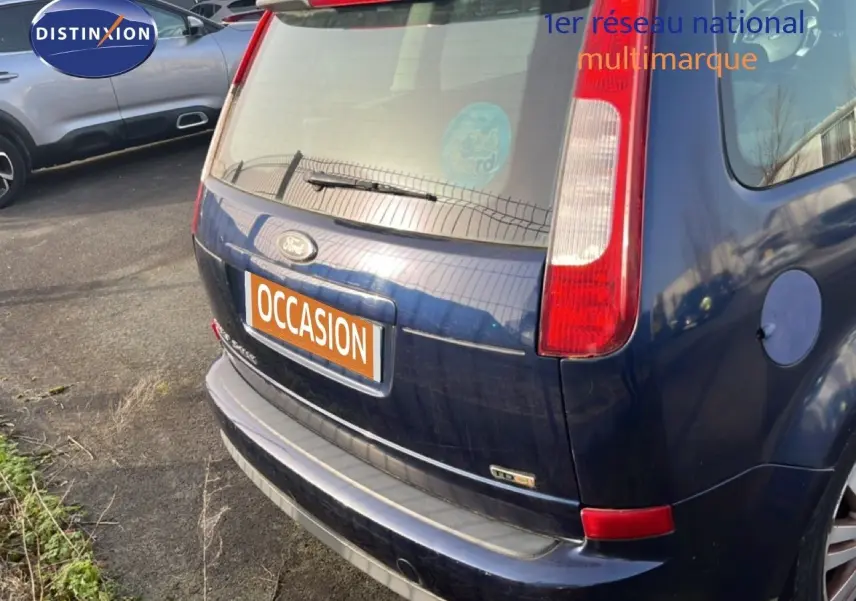 Vue 3/4 arrière droite d'une Ford C-MAX bleu foncé métal de 2005 avec feux arrière verticaux et hayon fermé.