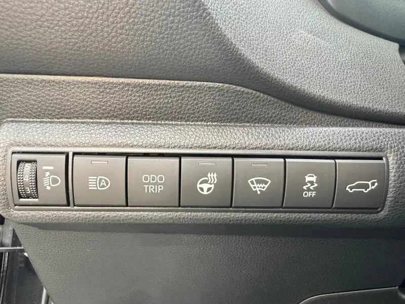 Vue rapprochée des commandes de tableau de bord en plastique noir de la Toyota Corolla 2025 hybride.