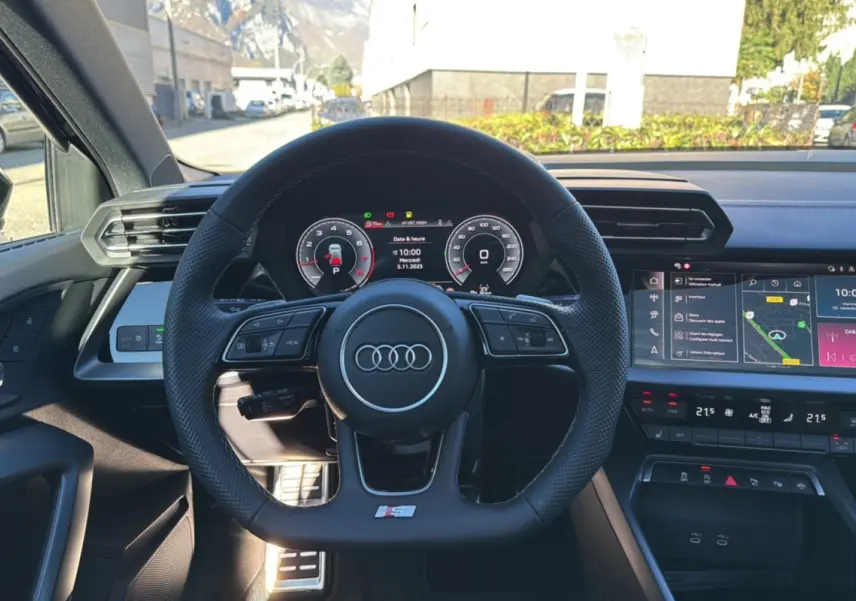 Vue intérieure centrée sur le volant cuir méplat S-Line et le tableau de bord numérique de l'Audi A3 2025.